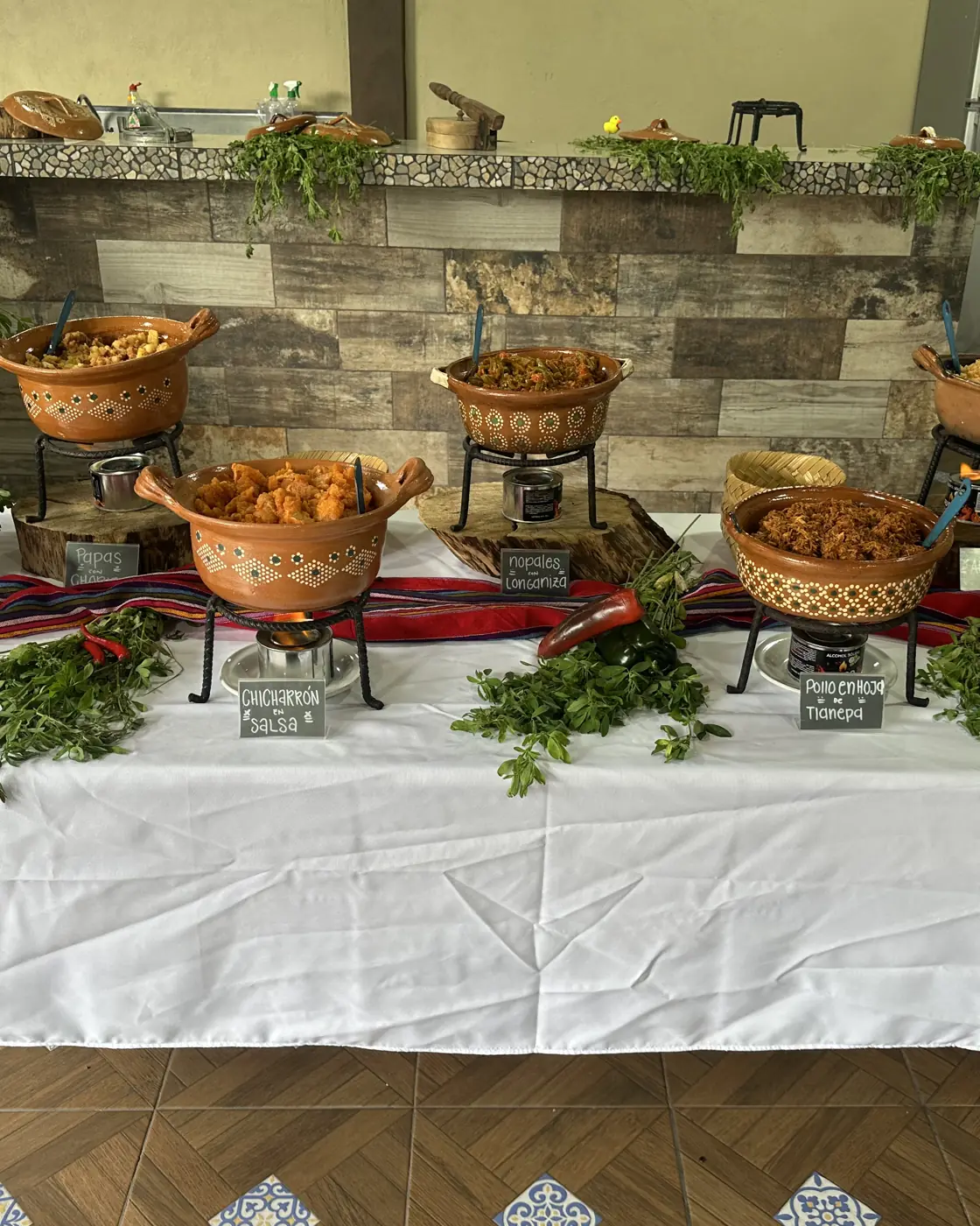 Mesa de guisados en cazuelas de barro con sus letreros