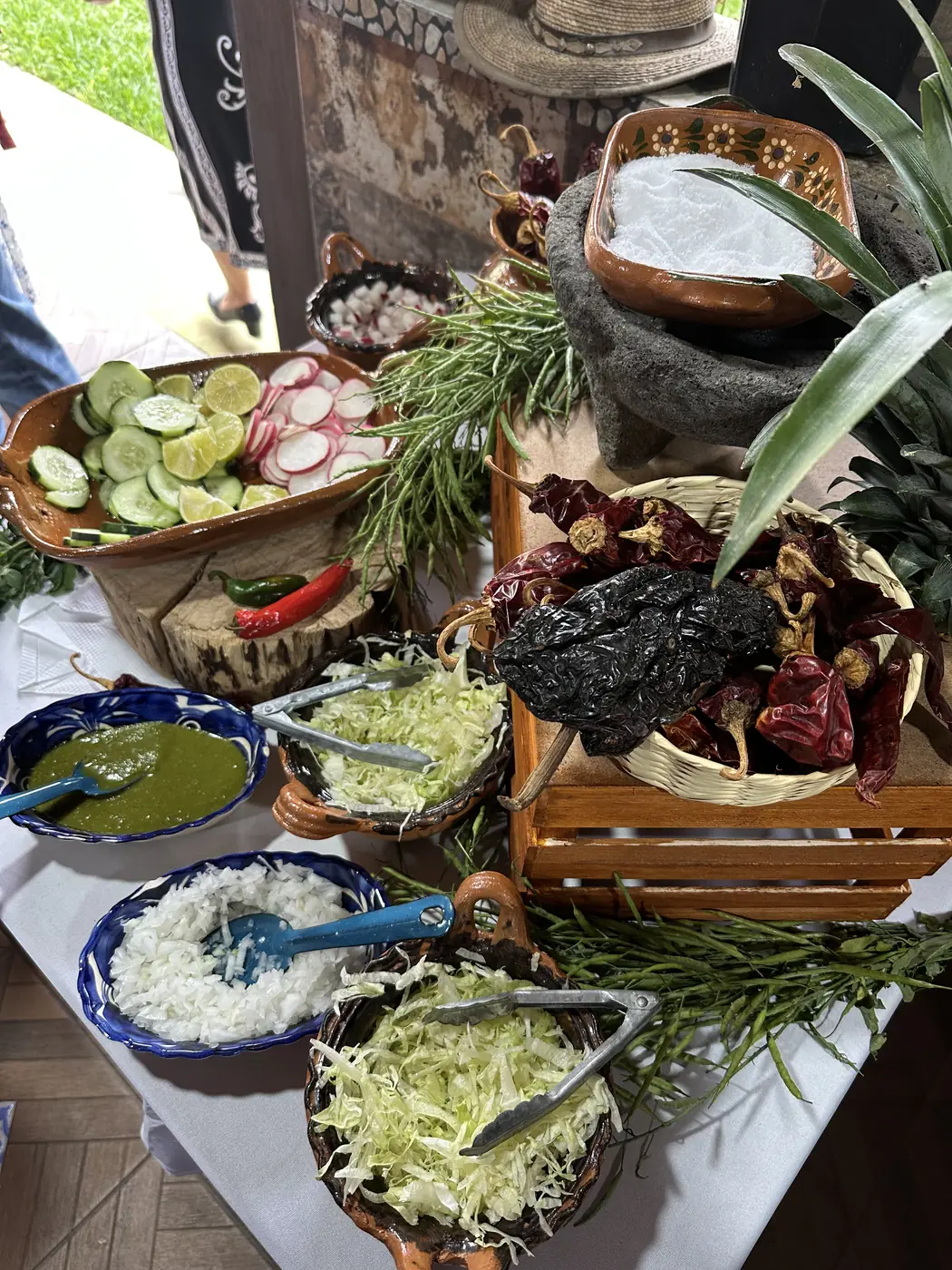 Estación de salsas con molcajete, chiles secos, pepino y rábano