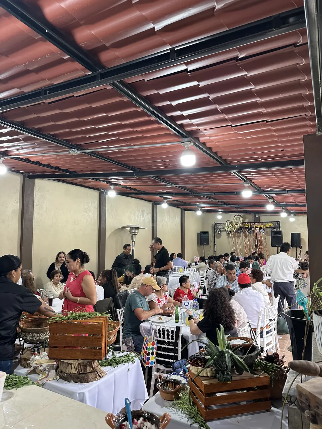 El salón lleno durante una fiesta, con la taquiza al frente